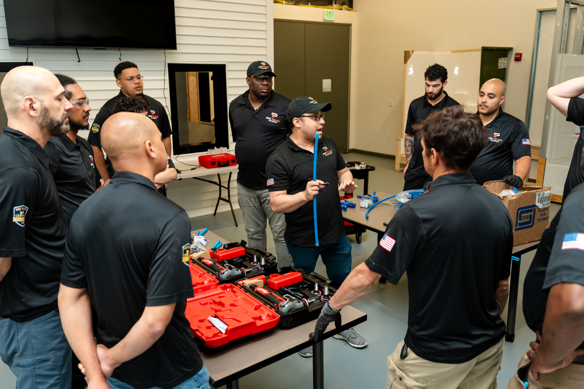 Instrutor demonstrando tubo PEX para turma em treinamento