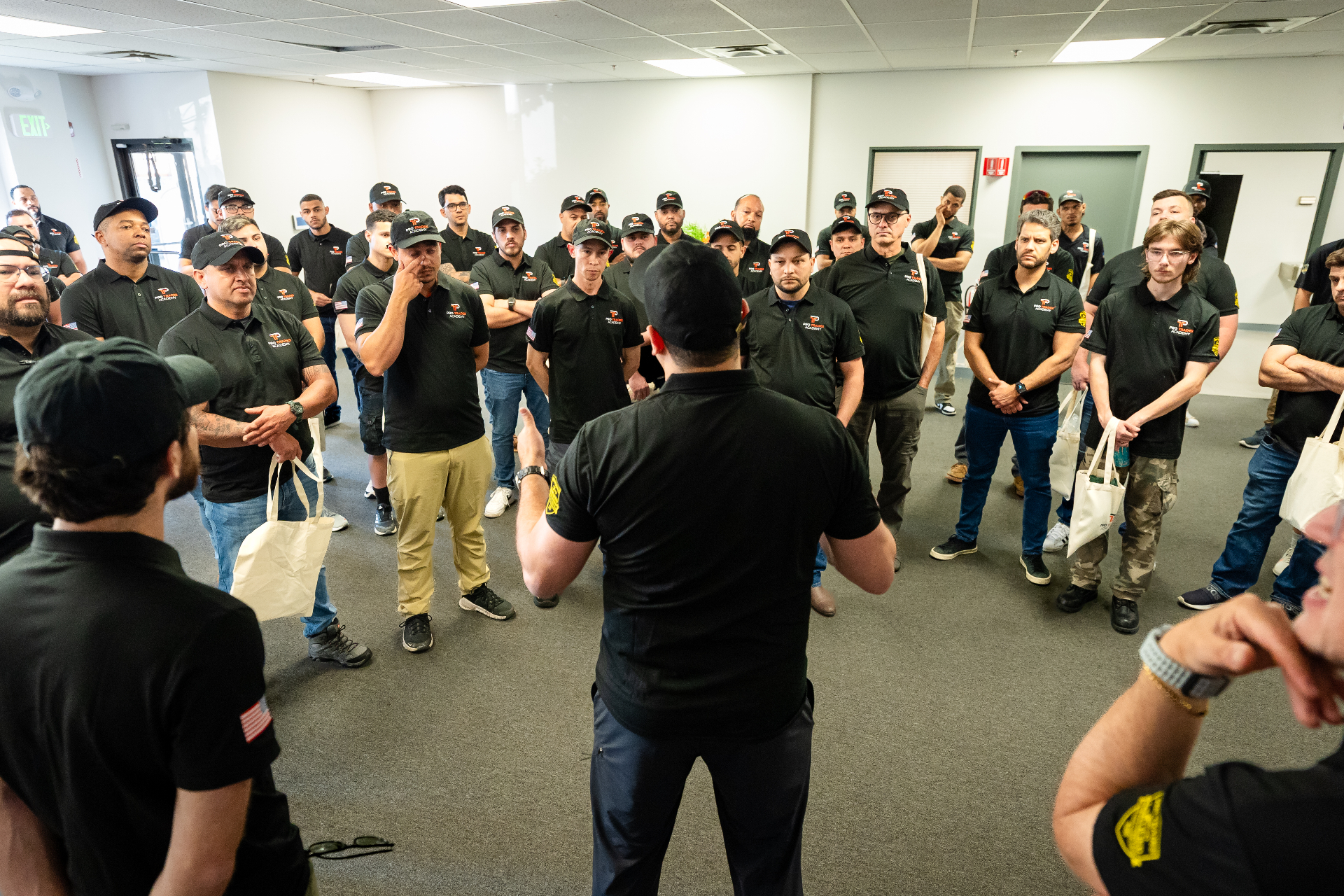 Instrutor da Pro Trades Academy reunido com turma de alunos uniformizados em aula prática